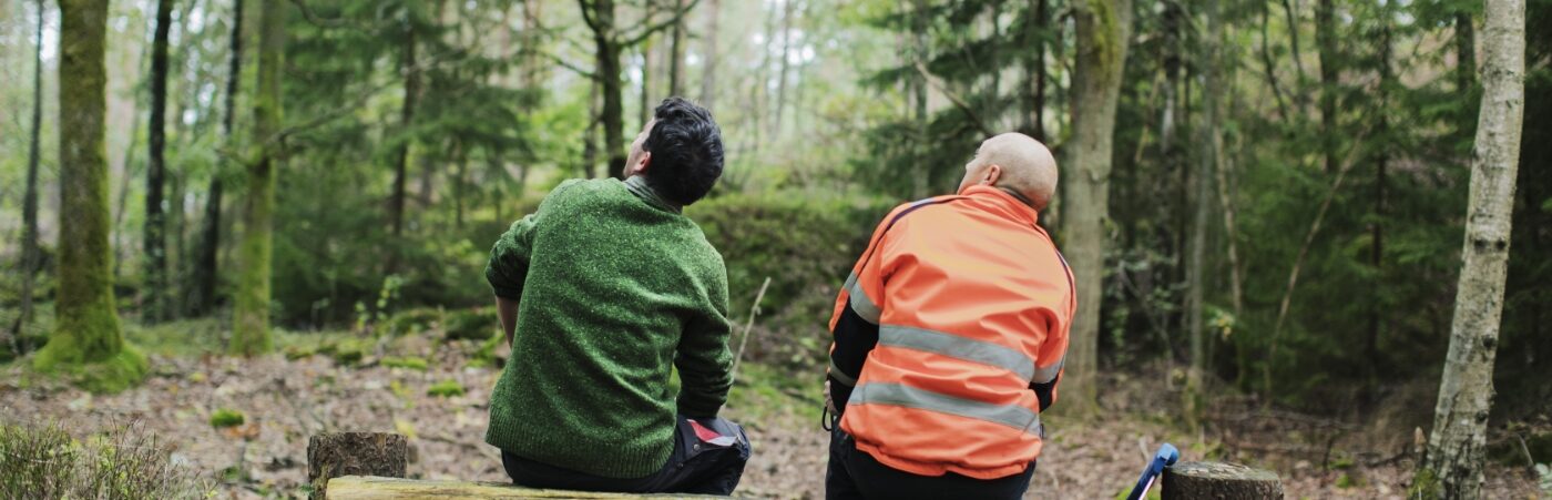 Två män sittandes i skogen